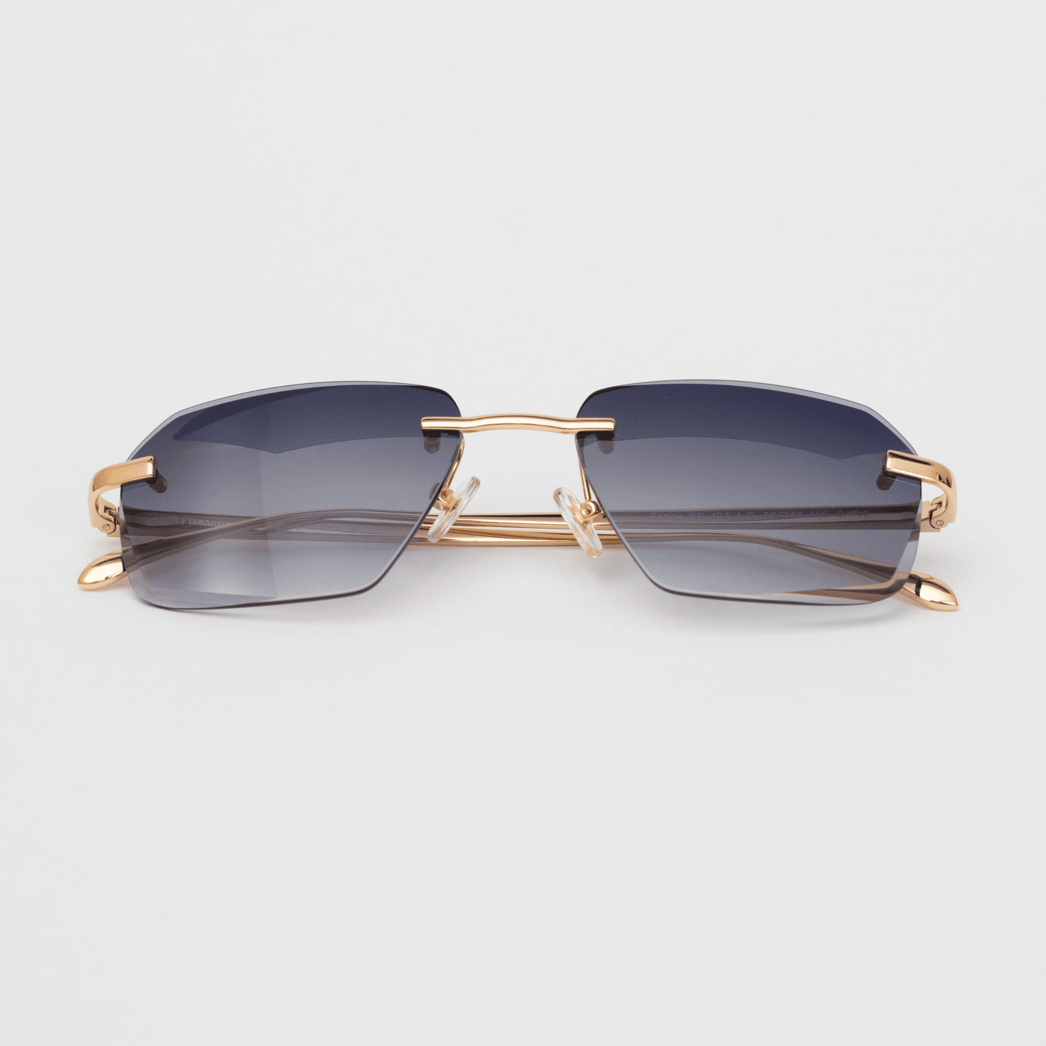 "Model Sancy sunglasses featuring a luxurious grey diamond-cut, rimless design with 18K gold detailing on the hinges and nose bridge, presenting a gradient blue tint, against a white backdrop.