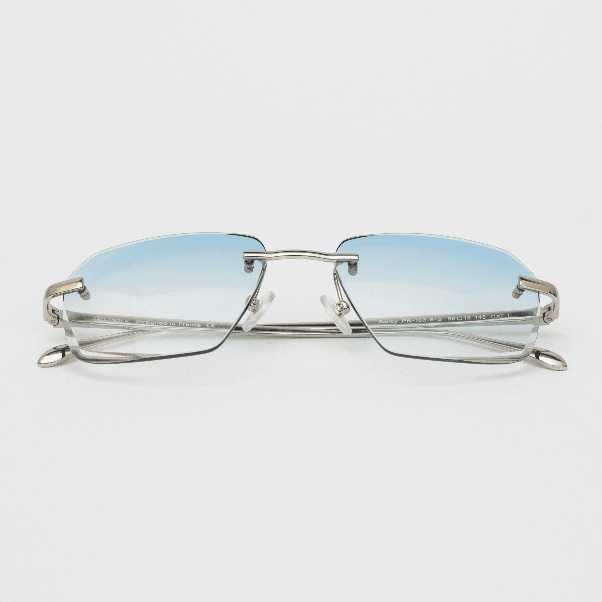 Front view of the Sancy model sunglasses featuring sky blue diamond-cut rimless lenses with sophisticated sterling silver frames, creating a fresh and airy aesthetic against a white background.